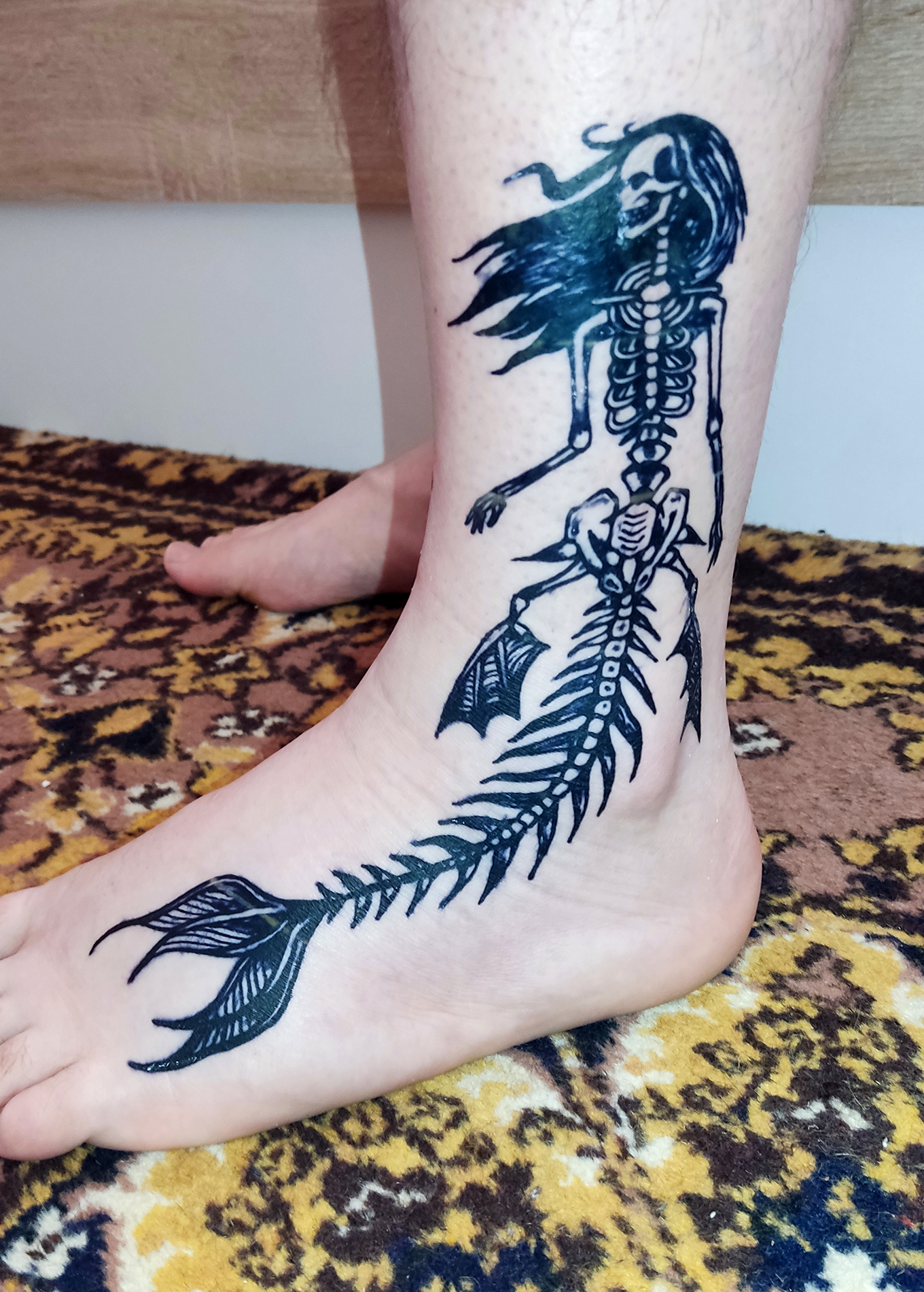 Временная татуировка на ноге. Скелет русалки